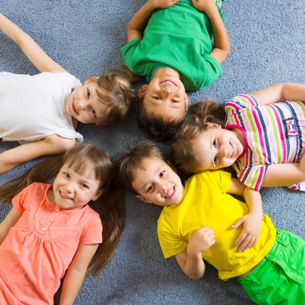 Cute little children lying on floor in kindergarten